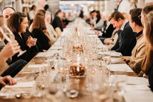 People dining at a long table, ready for bookings